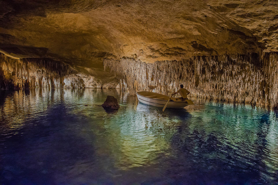 Boat ride through the Drach Caves Person rowing a boat through the Drach Caves