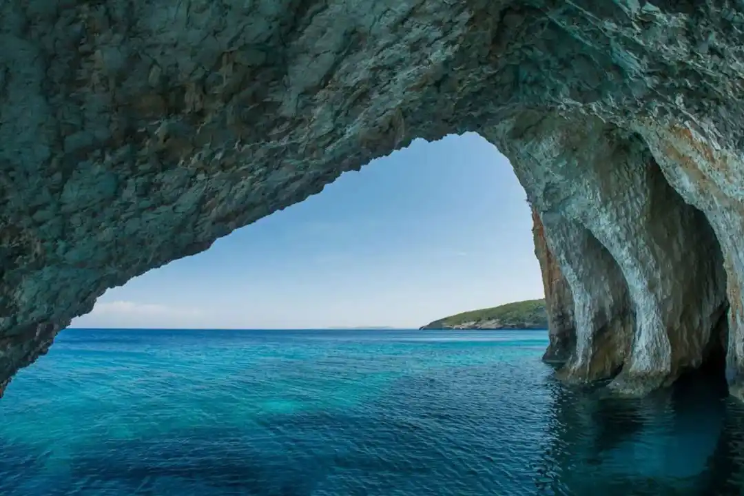 A beautiful view looking out from inside a rocky sea cave onto clear turquoise ocean water. A beautiful view looking out from inside a rocky sea cave onto clear turquoise ocean water.