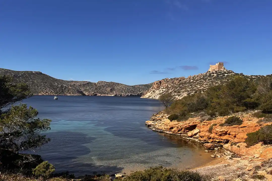 Ein schöner Blick auf eine ruhige Bucht, umgeben von felsigen Hügeln und einem alten Steinturm. Ein schöner Blick auf eine ruhige Bucht, umgeben von felsigen Hügeln und einem alten Steinturm.