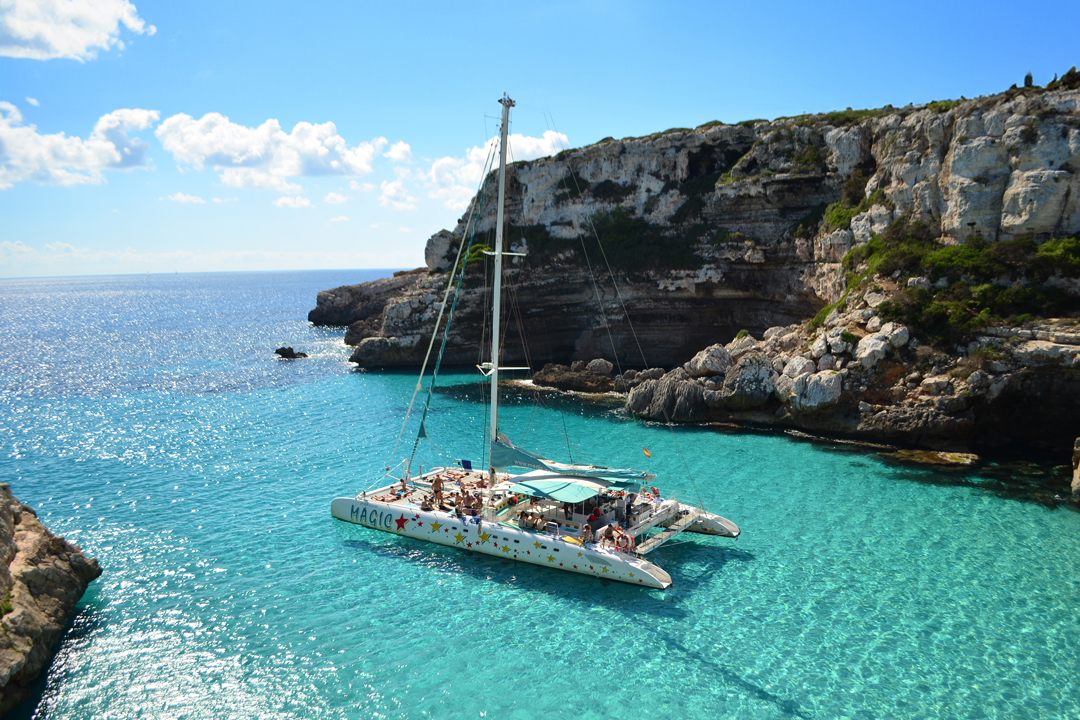 Katamaran Magic gleitet durch eine Bucht auf Mallorca