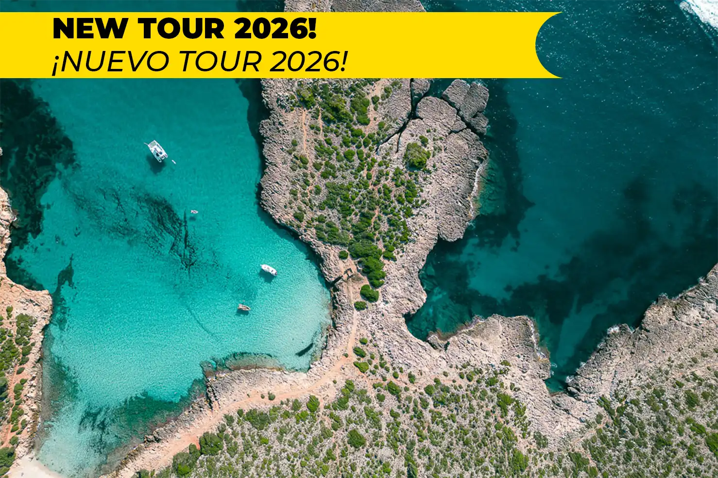 A white boat docked by an underground cave lake with turquoise illuminated waters and hanging stalactites.